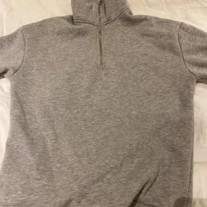 Grå Half Zip från KidsBrandStore - Mysig grå half zip från KidsBrandstore i mycket bra skick. Perfekt för kyliga dagar med sin mjuka insida. Enkelt att matcha med jeans osv. Nypris: Ca 500 kr.