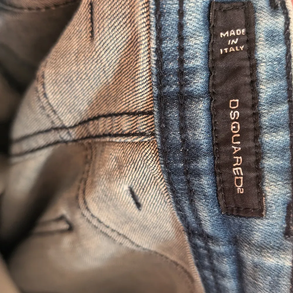 Säljer ett par snygga blå jeans från Dsquared2 med slitna detaljer för en cool look. De är i bra skick och har en normal passform. Perfekta för både vardag och fest!. Jeans & Byxor.