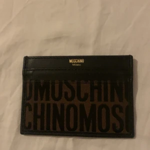 Moshino korthållare - Fin, stilren korthållare från moshino. Använd men i väldigt fint skick Tyvärr har jag ej kvittot kvar på denna. Nypris ca 2500kr