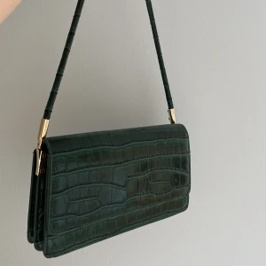 Grön baguetteväska  - Grön liten crocmönstrad baguetteväska från shein! Aldrig använd och är i ordentligt material