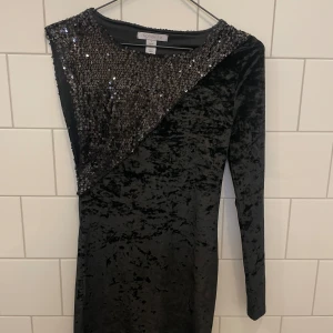 Glittrig festklänning - Glittrig enärmsklänning. Beställd ifrån Nelly för flera år sen men är i fint skick. 
