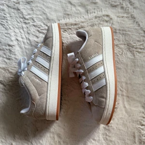 Adidas Campus 00S - Adidas Campus 00S i färgen wonder beige.  I toppenskick! Storlek 39 1/3. Köpta från JD sports, kvitto finns om det önskas. Har tyvärr inte kvar orginalkartongen.  Både vita & beiga snören följer med 🥰🙏🏼