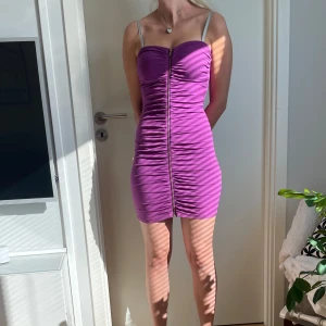 Snygg Lila med dragkedja  - Säljer min fina lila klänning som är i väldigt fint skick🥰 Den är utan band och sitter lätt kvar ändå. Klänningen har en dragkedja hela i vägen i fram.   Stl S men passar mer som XS   Obs🥰klänningen är lite för liten för mig på bilden! 