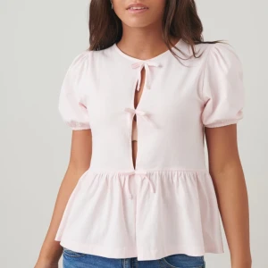 Ljusrosa blus med puffärmar - Säljer en superfin ljusrosa blus med puffärmar och knytning framtill. Den har en söt och luftig design med en lätt volang nedtill. Skriv om du vill ha fler bilder❤️