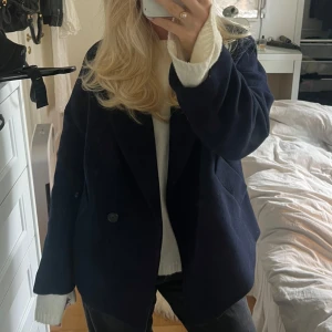 Mörkblå kort kappa - Säljer denna snygga, trendiga mörkblåa kappan perfekt till hösten. Köpt på Lindex för 1000 kr. Använd en höst, inga tecken på användning.