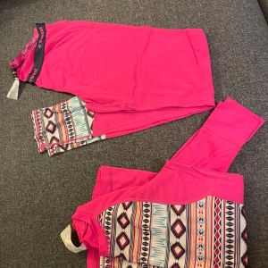 Underställ  - Snygg underställströja och byxor i rosa med mönster i vitt, svart, blått och rött. Tröja i storlek 36, byxor i storlek 38