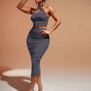 Grå klänning med halterneck - Snygg grå klänning med halterneck och tight passform.  Storlek S aldrig använd. 89kr