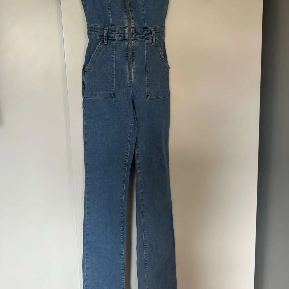 Säljer nu min fina jeansjumpsuit då den inte kommer till användning. Endast använd en gång. Bootcut i benen. Jeans & Byxor.