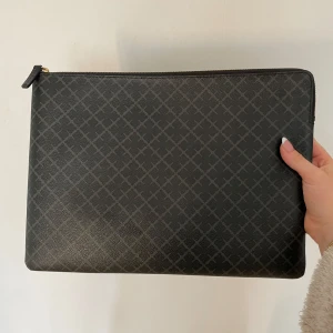 Svart kuvertväska med mönster - Malene Birger datorfodral i fin fin skick, en liten svart fläck innuti men annars som ny. Köpte den för 1600!