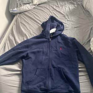 Säljer nu min marinblåa Ralph lauren hoodie pga jag har växt ur den den är i fint skick ganska ny. Storlek 14-16 men passar också 13.