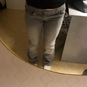Grå bootcut jeans - Snygga grå bootcut jeans med en klassisk look. De har en normal passform och är perfekta för en avslappnad stil. Jeansen har en lågmidjad design och är tillverkade i ett bekvämt material.