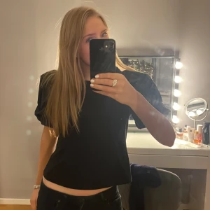 Svart topp med puffärmar - Snygg svart topp från H&M med puffiga kortärmar. Perfekt för en stilren look eller vid festligare tillfällen💕