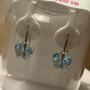 Blomdahls örhängen  - Hudvänliga örhängen i ren medicinsk titan och plast. Hängande fjäril - helt nya i försluten ask 120 kr  (Nypris 249 kr) Stjärna och blomma 75kr/st  Använda fåtal gånger.  Alla för 250 kr.