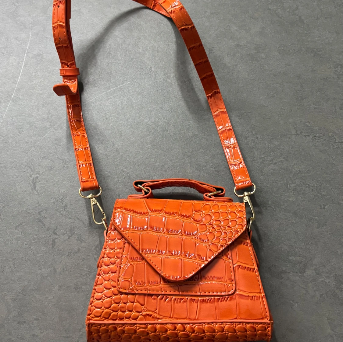 Orange axelväska med krokodilmönster