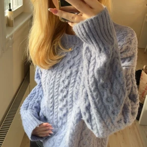 Ljusblå stickad tröja från MNG - Säljer en mysig ljusblå stickad tröja från MNG. Tröjan har ett klassiskt flätmönster och långa ärmar med ribbade muddar. Perfekt för kyliga dagar och ger en stilren look. Köptes i Gran Canaria 💕