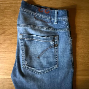 Dondup Jeans George  - Säljer ett par riktigt snygga jeans från Dondup med slitna detaljer. Modellen är George skinny fit i strl 33. Skick 7/10, använda ett tag men är lika snygga fortfarande. Hör gärna av er! Priset kan ändras vid snabb affär! 