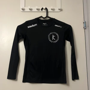 Svart långärmad tröja från Craft - Säljer en svart långärmad tröja från Craft med tryck på bröstet och axlarna. Perfekt för träning eller vardagsbruk. Tillverkad i ett mjukt och bekvämt material.