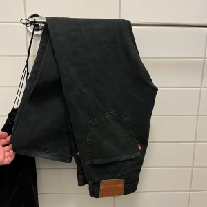 Svarta Levis 501 jeans - Säljer ett par klassiska svarta Levis 501 jeans. De har en rak passform och är tillverkade i slitstarkt denim. Perfekta för en stilren look.