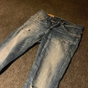 Dondup George - Snygga blå skinny jeans från George med slitna detaljer och en cool tvätt. Perfekta för en avslappnad stil med en touch av edge. De har en klassisk femficksdesign och knappgylf. pris diskuterbart