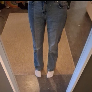 Blå jeans i storlek S/32 - Säljer ett par klassiska blå jeans med hög midja och straight passform. Perfekta för en avslappnad stil. De har en enkel design med fem fickor och knappgylf. Är knappt använda