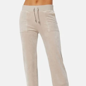 Beige Juicy Couture byxor  - Snygga beige mjukisbyxor med snörning i midjan och praktiska fickor fram och bak. Perfekta för en avslappnad stil. (Mycket bra skick. Den ena knappen på snöret saknas) 