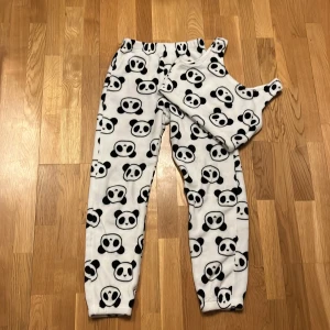Vit och svart panda-mönstrad topp och byxor från Shein Shein - Mysig vit och svart panda-mönstrad topp och byxor från Shein. Setet är tillverkat i mjuk fleece och har ett gulligt pandamönster över hela plagget. Perfekt för en avslappnad dag hemma eller som en rolig pyjamas.❤️🤍