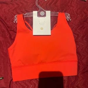 Röd linnetopp från Athlecia - Snygg och sportig röd linnetopp från Athlecia. Perfekt för träning med sin bekväma passform och stilrena design. Toppen är ärmlös och har en bred resår under bysten för extra stöd.