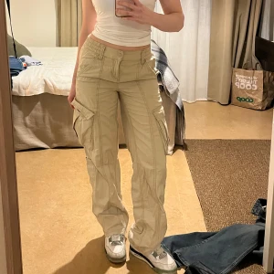 Beige cargobyxor - Snygga beige cargobyxor. Rak passform och resår i midjan! Mid waist. 