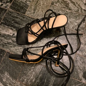 Svarta sandaler med snörning - Stilrena svarta sandaler med snörning och fyrkantig tå. Höjd på klackskorna: 7cm