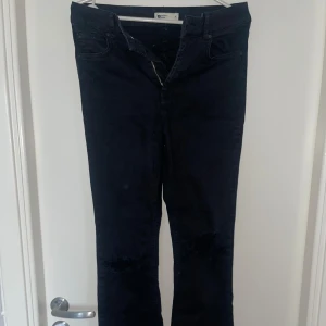 Svarta jeans från Perfect Jeans - Snygga svarta jeans från Perfect Jeans i storlek M. De har en modern, sliten look med hål på knäna.