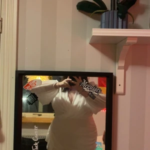 Vit omlottklänning - Elegant vit omlottklänning med långa ärmar och knytning i midjan. Perfekt för en stilren look.