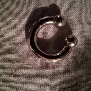 Näsring i kirurgiskt stil med mönster  - Snygg och stilren silverfärgad näsring med en unik, vågig design. Perfekt för att ge en modern touch till din look. Fråga om mått då jag säljer åt en vän, har inte hål själv! Aldrig använd!