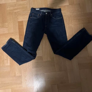 Mörkblå jeans från Levi's - Snygga mörkblå jeans från Levi's med klassisk femficksdesign och knappgylf. Perfekta för en avslappnad stil. Levi's logga syns på bakfickan. Priset kan diskuteras 