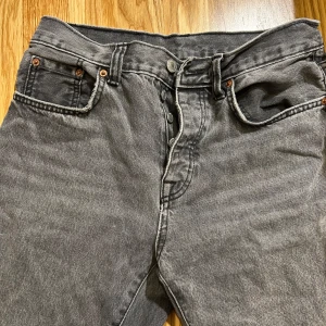 Grå jeansbyxor - Snygga grå jeansbyxor med klassisk femficksdesign och knappgylf. Perfekta för en avslappnad stil. De har en rak passform och är tillverkade i slitstarkt denim.