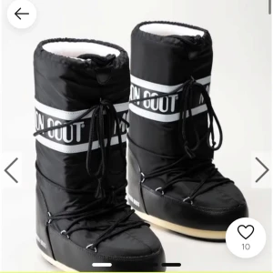 Svarta Moon Boots med snörning - Snygga svarta Moon Boots med vit text och snörning. Perfekta för kalla vinterdagar med sin varma och bekväma design.