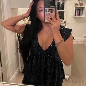 Glittrig topp från Nelly - Snygg glittrig topp med volang från Nelly i mörkblått💙Storlek XSS men passar toppen på mig som vanligtvis är XS/32. Perfekt för fest, jul, nyår mm!✨ Toppen är i nyskick med lappen kvar, endast provad på😇