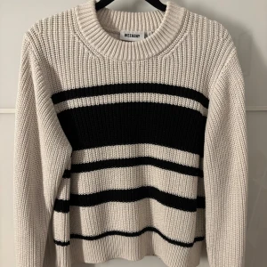Randig stickad tröja - Säljer en fin stickad tröja från Weekday i beige och svart. Tröjan har ett randigt mönster och långa ärmar, kommer inte längre till användning. Har dock blivit lite nopprig men inget man tänker på.