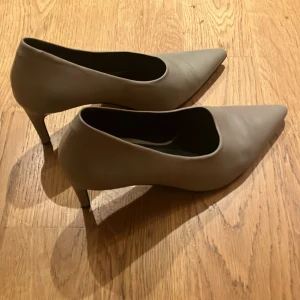 Beige pumps tiger of Sweden - Eleganta beige pumps med spetsig tå och hög klack. Perfekta för en stilren look. Näst intill oanvända. Säljer pga för små,