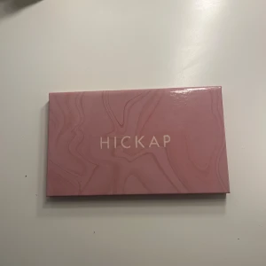 Ögonskuggspalett från Hickap - Snygg ögonskuggspalett från Hickap med 12 olika nyanser. Paletten har en mix av matta och skimrande färger, perfekt för att skapa både vardags- och festlooks. Den kommer i en stilren rosa förpackning med inbyggd spegel. Bara några av skuggorna är endast testade!