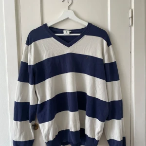 Randig tröja från Boomerang - Säljer en snygg randig tröja från Boomerang i storlek XL. Tröjan är blå och vit med breda horisontella ränder. Den har en v-ringad hals och långa ärmar. Perfekt för en casual look!