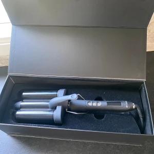 Vågtång lyko  - Endast använd 1 gång, legat i sin box sedan dess så i fint skick! Köpt i lyko butik förra året, nypris 649kr  - Anpassade värmlägen 120–210°C för att passa alla hårtyper. - Snabb uppvärmning för att spara tid. - 3-meters sladd med ett vridbart fäste 