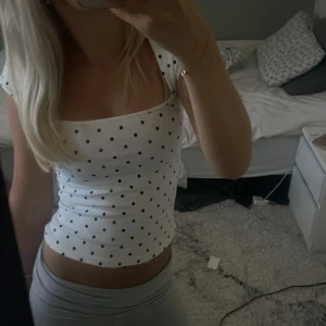 Vit prickig topp från H&M Divided - Säljer en super söt vit topp med svarta prickar från H&M💕. I storlek xxs den sitter ganska tajt!💕super fin!!