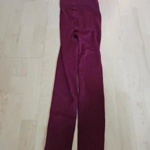 Vinröda leggings - Säljer ett par vinröda leggings. De är superbekväma och perfekta för både vardag och träning. De har en hög midja som ger bra stöd och en tight passform som framhäver benen. Materialet är mjukt och stretchigt, vilket gör dem sköna att ha på sig hela dagen.
