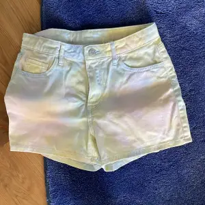 Säljer ett par ljusgula shorts från H&M. De är i storlek 34 och har en normal passform. Shortsen är gjorda av bomull och har en knapp och dragkedja framtill. Perfekta för sommaren! 🌞