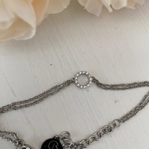 Snyggt armband från Edblad  - Jättefint och originellt armband från Edblad. Dubbla rader och med vacker cirkel med kristaller. Nytt och 21 cm långt.