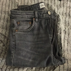 Gråa jeans med hål i knäna och med slitz  - Bra skick och sitter jätte fint på