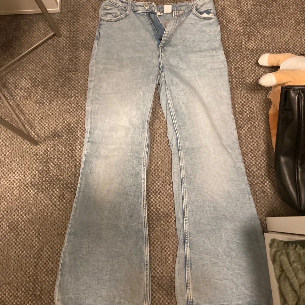 Säljer ett par ljusblå jeans med en söt hjärtdetalj på bakfickan. De har en loose passform och är perfekta för en avslappnad stil. Jeansen är högmidjade och har en klassisk femficksdesign. Perfekta för både vår och sommar!. Jeans & Byxor.