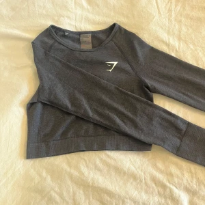 Gymshark träningströja - Svart gymshark vital seamless long sleeve crop top i strl Medium. Croppad långärmad träningströja med hål för tummarna!  Väldigt lite använd🌸 Köparen står för frakten💞