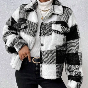 Svartvit rutig teddyjacka - Säljer en supermysig svartvit rutig teddyjacka som är perfekt för kyliga dagar. Jackan har en oversized passform och långa ärmar, vilket gör den både bekväm och trendig. Den har knappar framtill och två stora fickor på bröstet. Perfekt för höst och vinter!