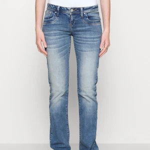 Blå bootcut jeans - Säljer ett par snygga blå bootcut jeans i klassisk stil. De har en normal passform och är perfekta för både vardag och fest. Jeansen har en knapp och dragkedja framtill samt fem fickor. De är i ett slitstarkt denim-material som håller länge.